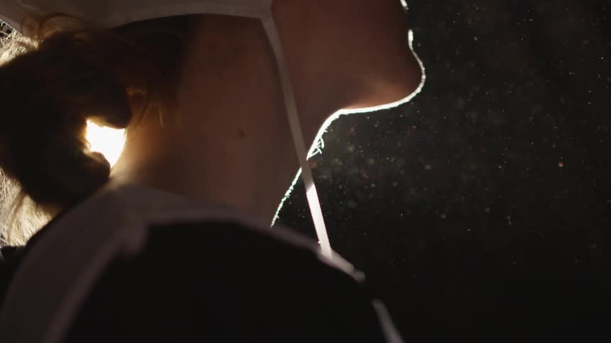 A close up of a woman's chin and hair with bright light shining through