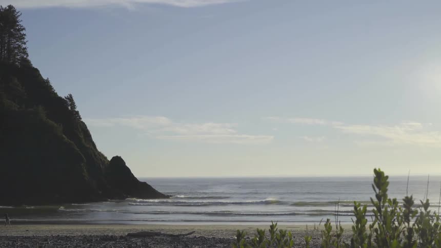 Sun rises over calm seas and a hill