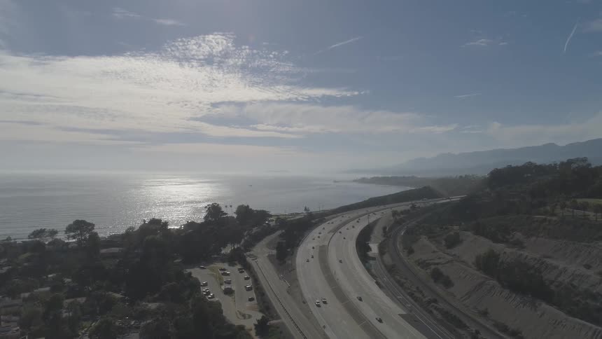 The highway curvy by the water and is full of cars