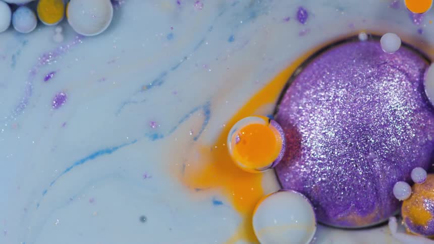 Purple and orange bubbles in white liquid