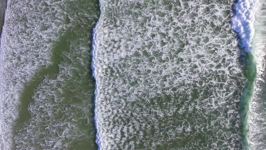 Ocean waves flow towards a sandy shore