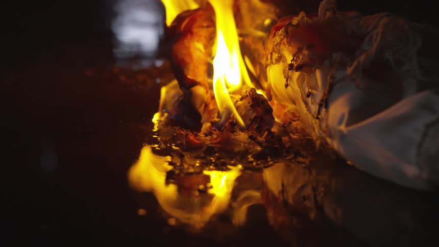 Reflection of flames on puddle from object on fire