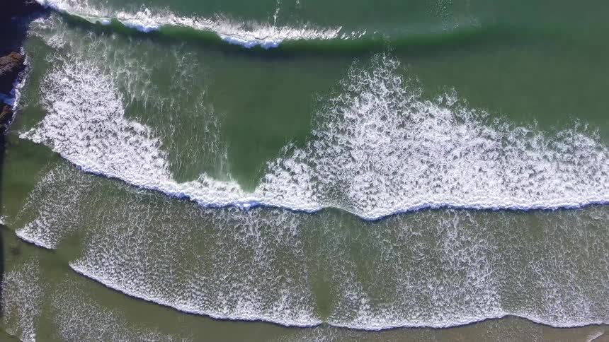 Aerial footage of beach waves coming into shore