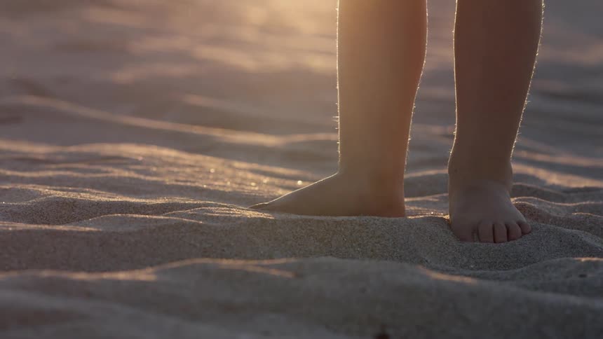 A boy standing in sand
