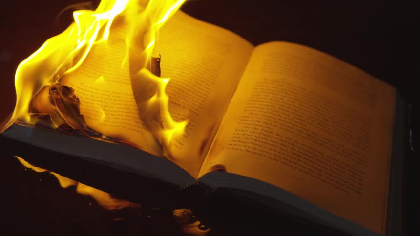 A book open and caught on fire at night