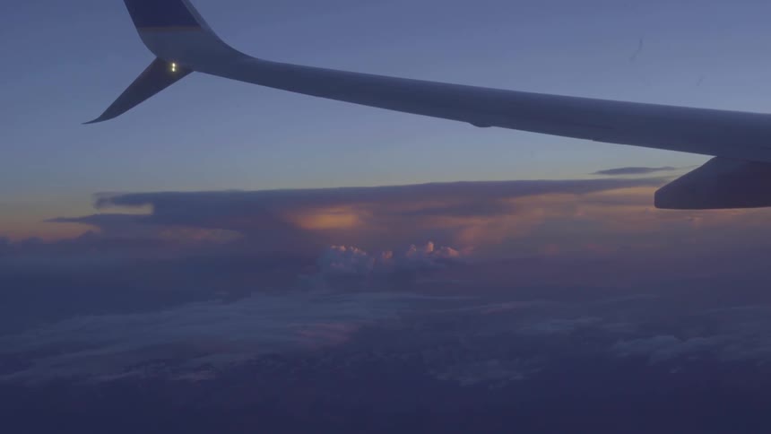View from airplane window over sunset
