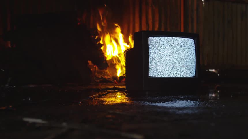 A television is turned on while a fire is burning