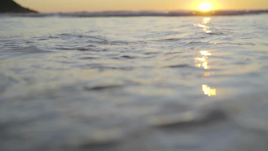 Small waves in ocean at sunset