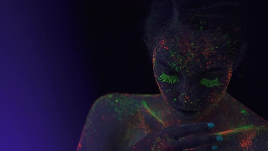Person splashed with psychedelic colors under a blacklight