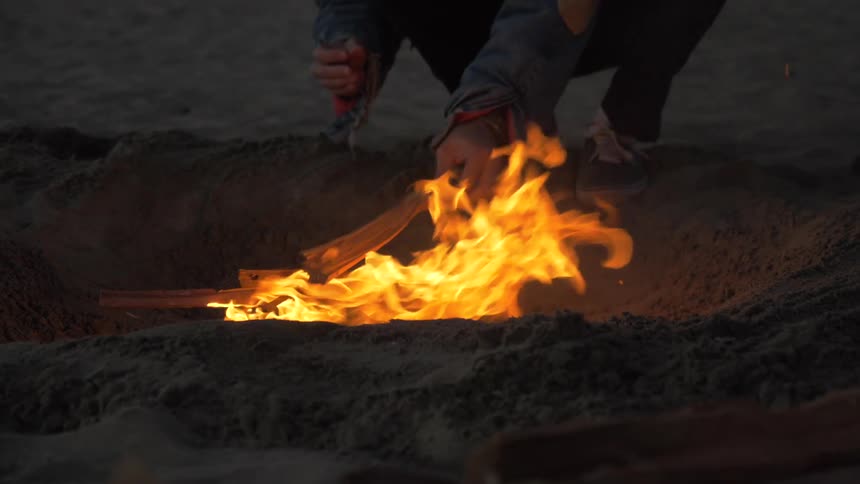 Man Building Fire On The Beach