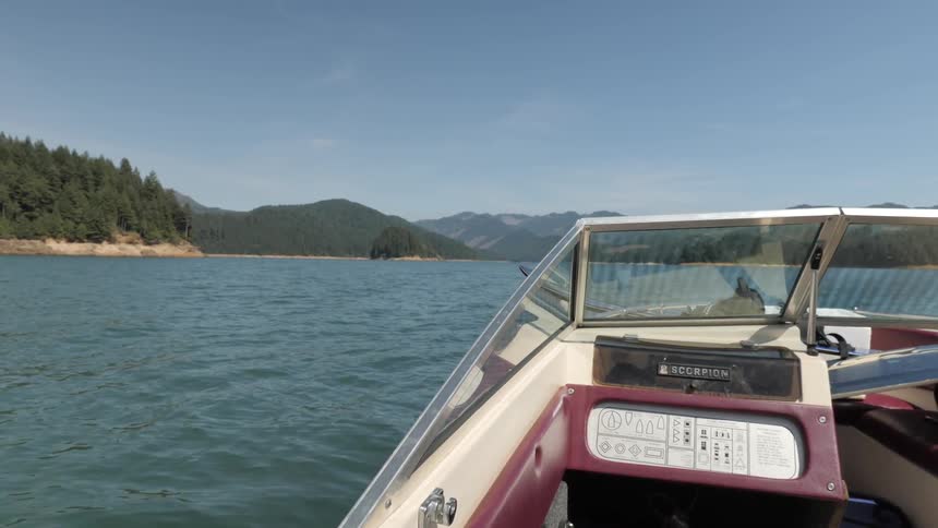 Man Driving Boat Around Lake