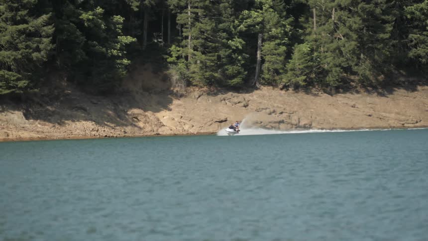 Man Driving Boat Around Lake