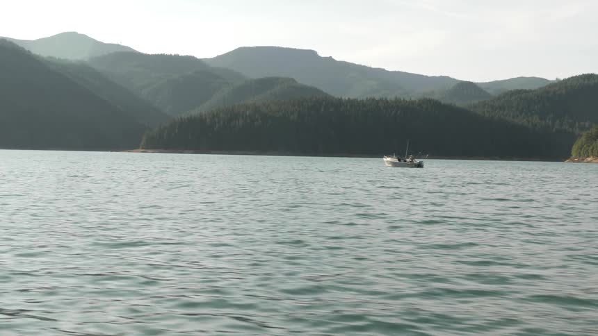 Man Driving Boat Around Lake