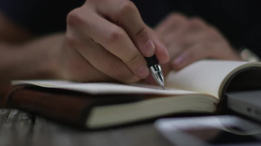 A person writing in a notebook
