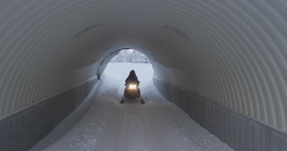 Riding Snowmobiles Through Forest