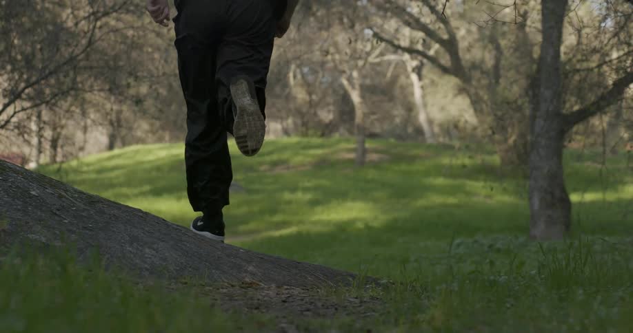 A man running through a grassy and wooded area