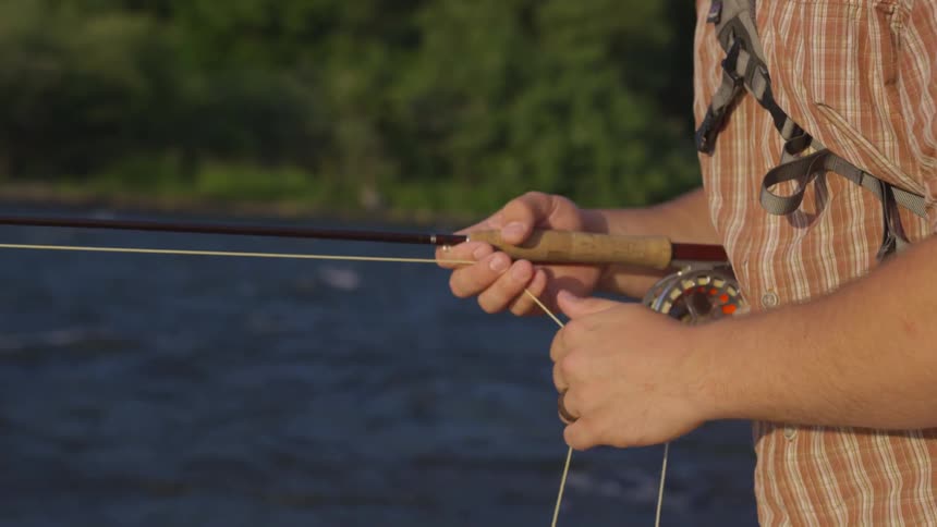 A man is holding a fishing pole outdoors