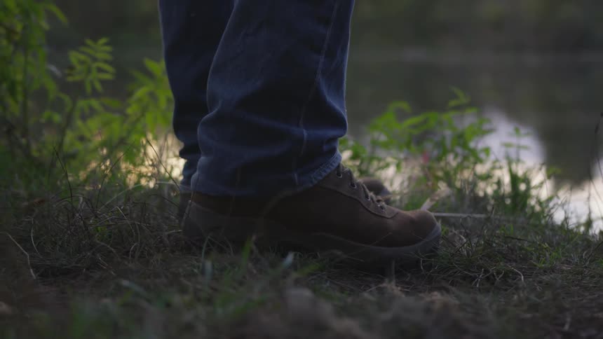 Person stands on shore of waterway