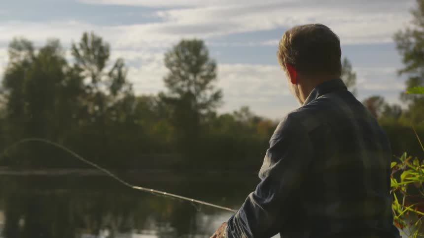 A man throws his fishing rod into the lake