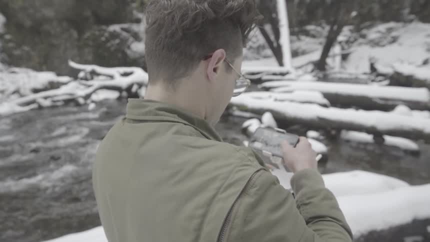 Man uses controller and cell phone outdoors