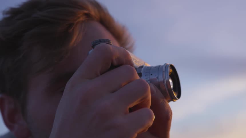 White man taking picture with a camera