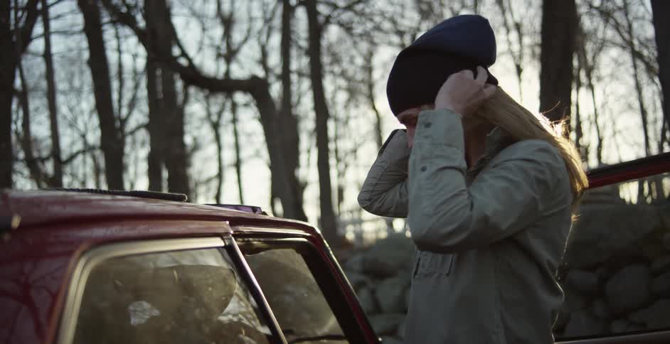 A person putting on a beanie