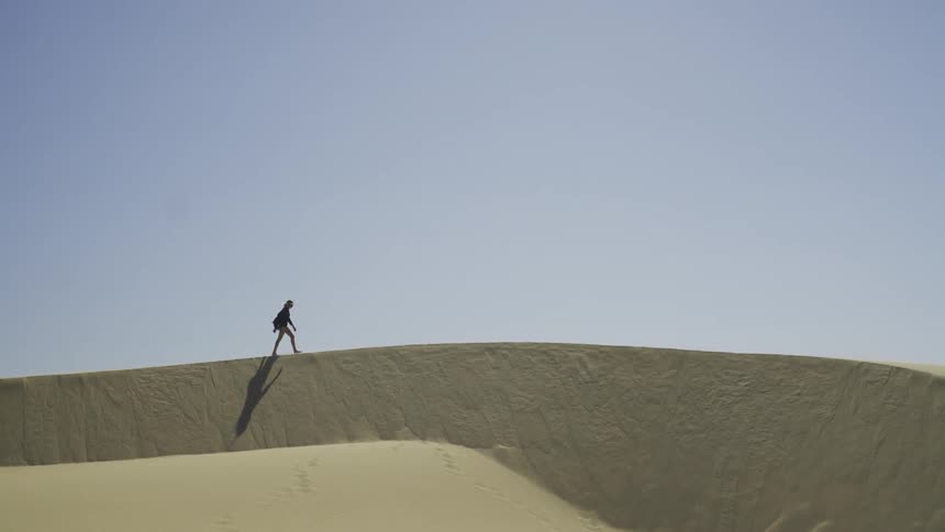 A person walking on a sand dune