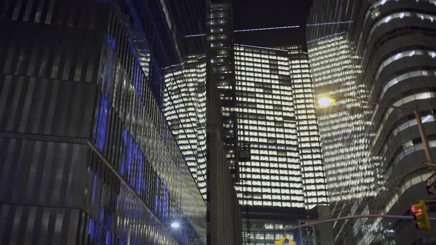 City buildings towering overhead at night