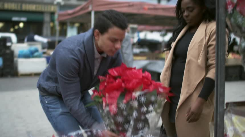 Man picks up flower bouquet for a woman to smell