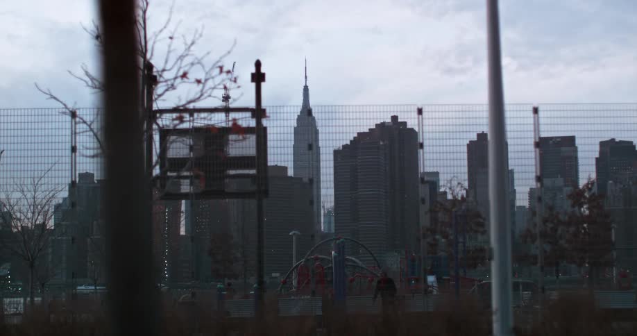 A tall fence with skyscrapers in the background