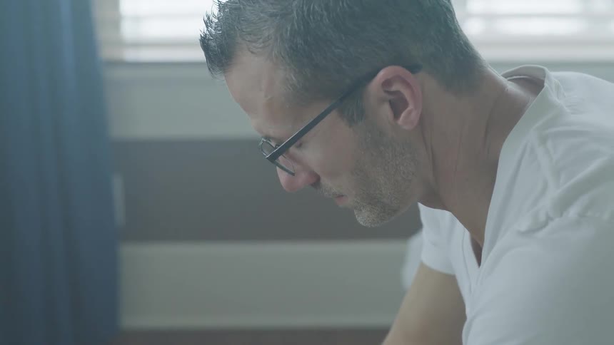 Man Sitting And Thinking On Bed