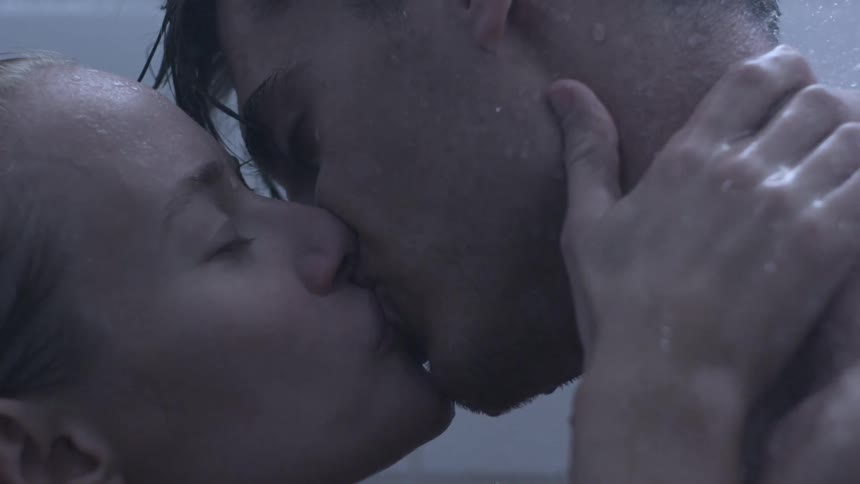 Man and woman kiss while showering