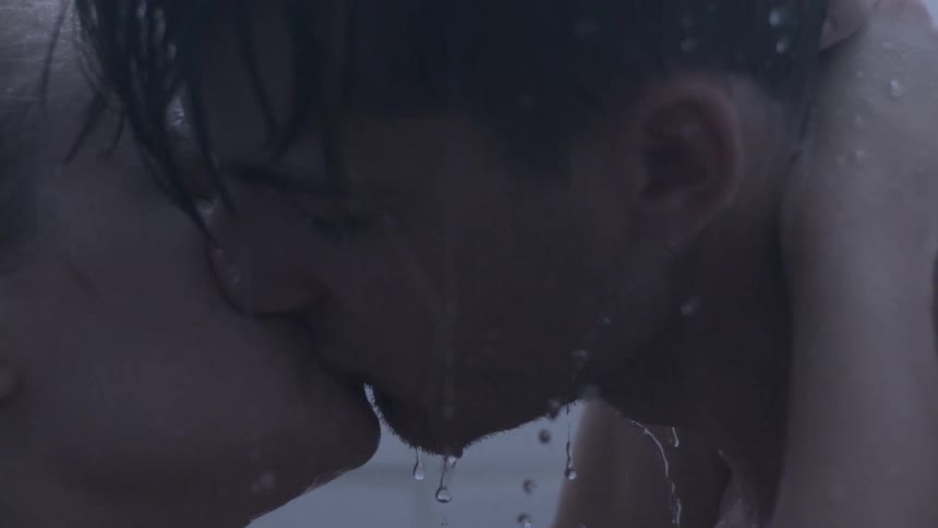 Man and woman kiss while showering
