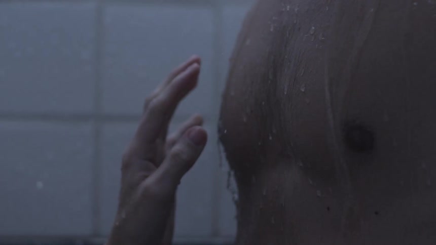A woman touching a man's bare chest in the shower