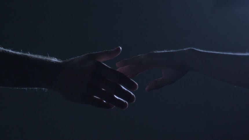 Two hands reaching out and coming together