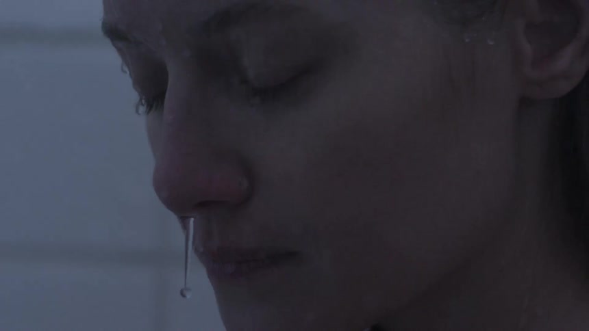 Woman with her eyes closed with water running over her face