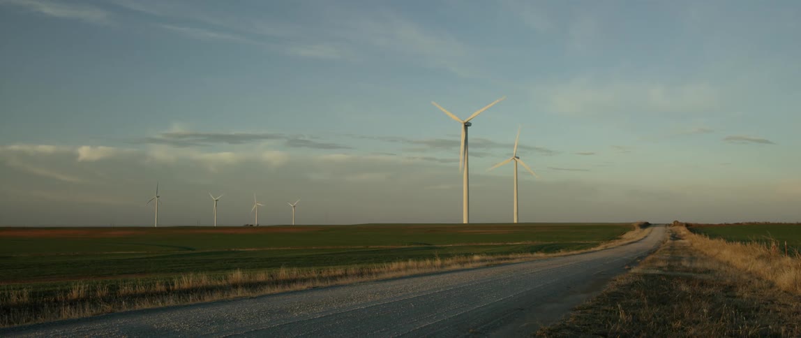 Windmills turning in an open field in the country