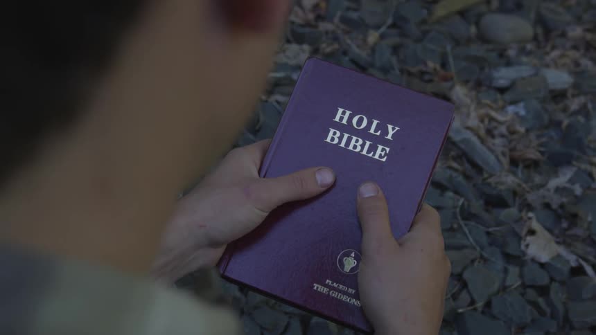 Man With Bible Walking On Train Tracks