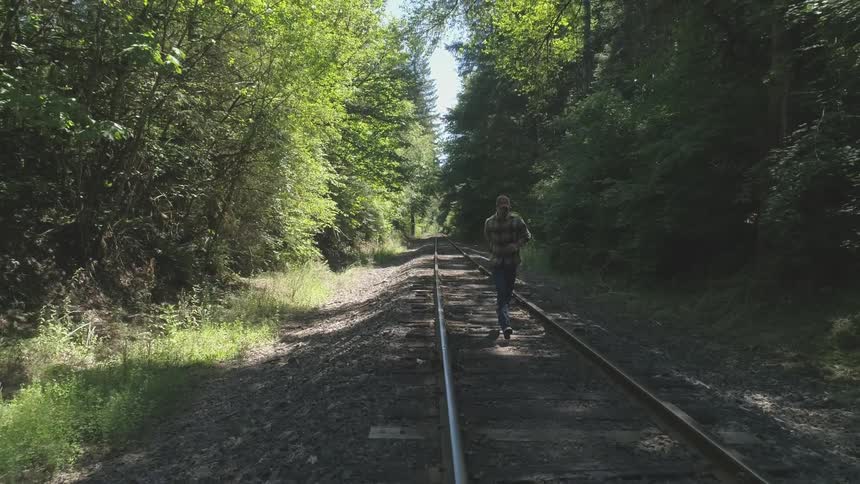 Man With Bible Walking On Train Tracks