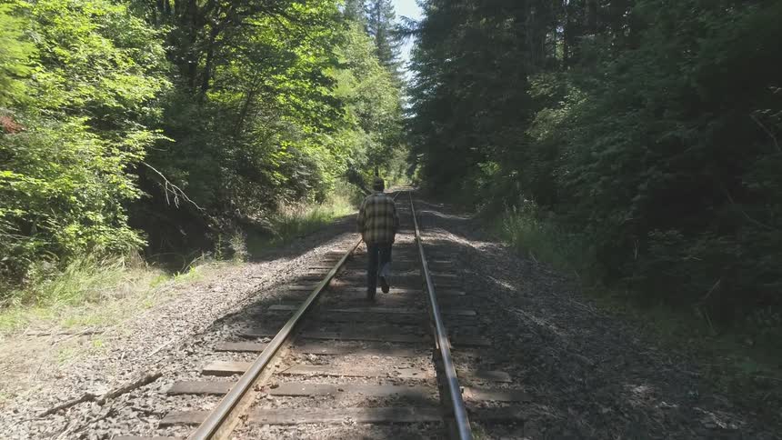 Man With Bible Walking On Train Tracks