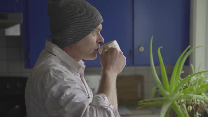 Man Working On Computer At Kitchen Table