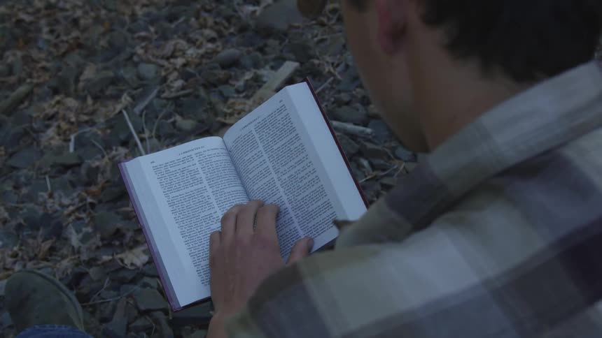 Man With Bible Walking On Train Tracks