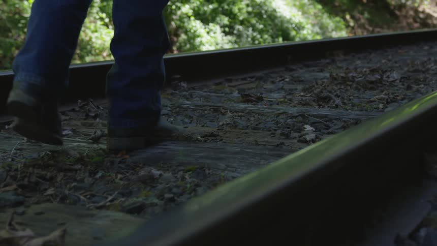 Man With Bible Walking On Train Tracks