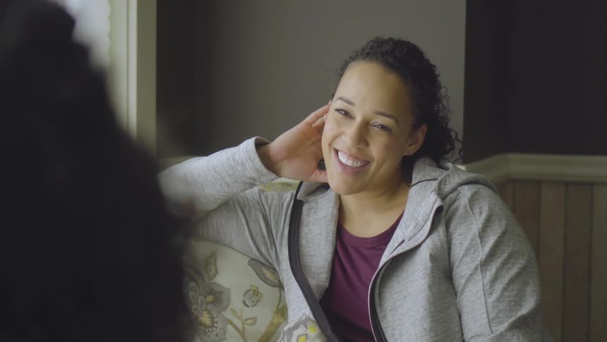 Mom And Daughter Talk In A Living Room