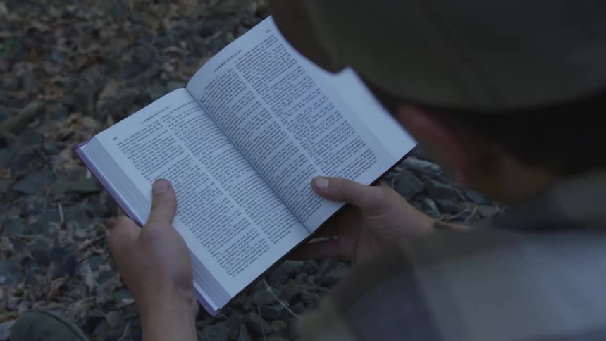 Man With Bible Walking On Train Tracks