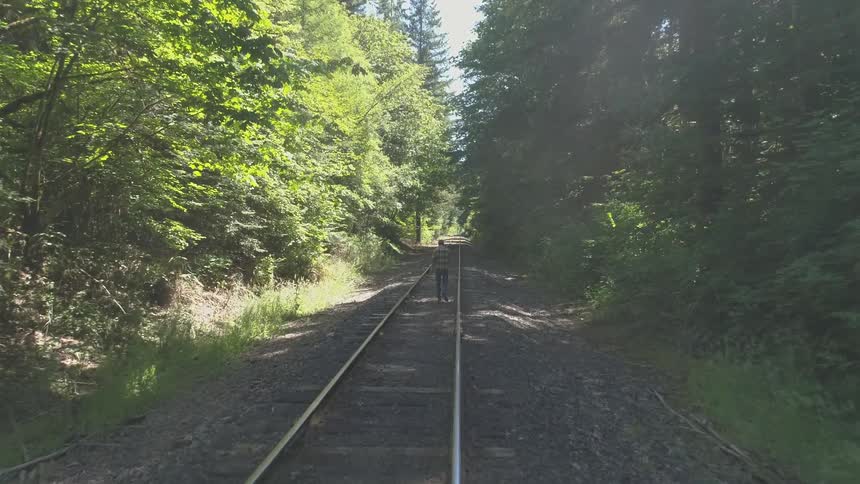 Man With Bible Walking On Train Tracks
