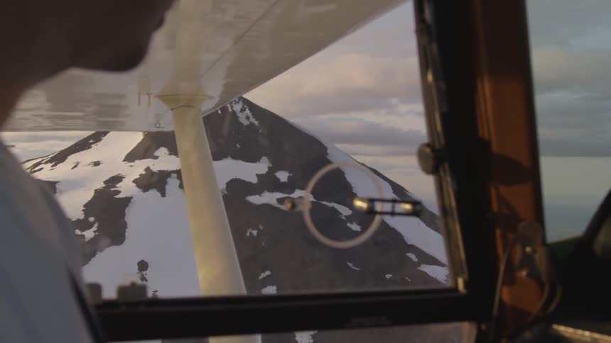 Pilot Flying Plane Through Snowy Mountains