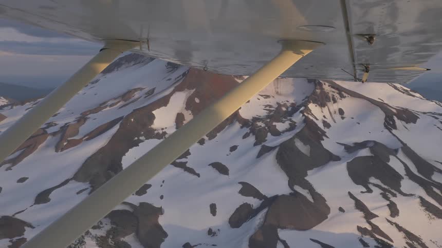 Pilot Flying Plane Through Snowy Mountains