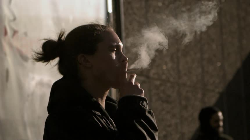 Man smoking as he stands outside