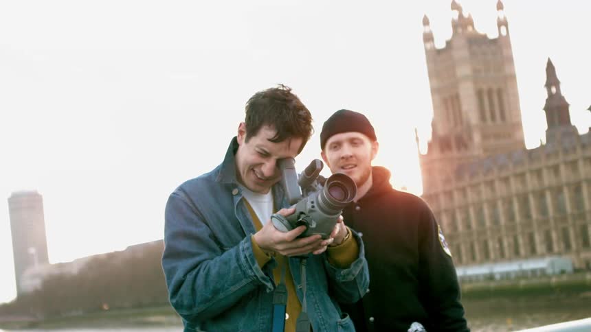 A man video recording in a city
